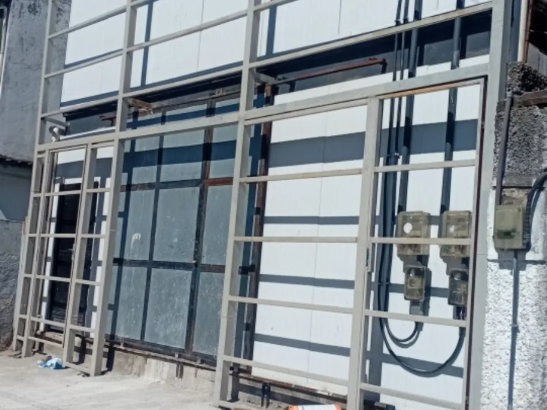 Estrutura metálica da fachada montada, ainda sem revestimento, com portão de acesso em fabricação