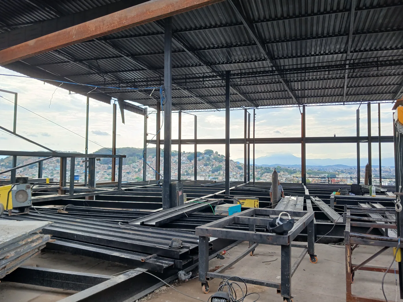 Canteiro de obras da CCR.SP: montagem de estrutura metálica com equipamentos de solda em pavimento elevado